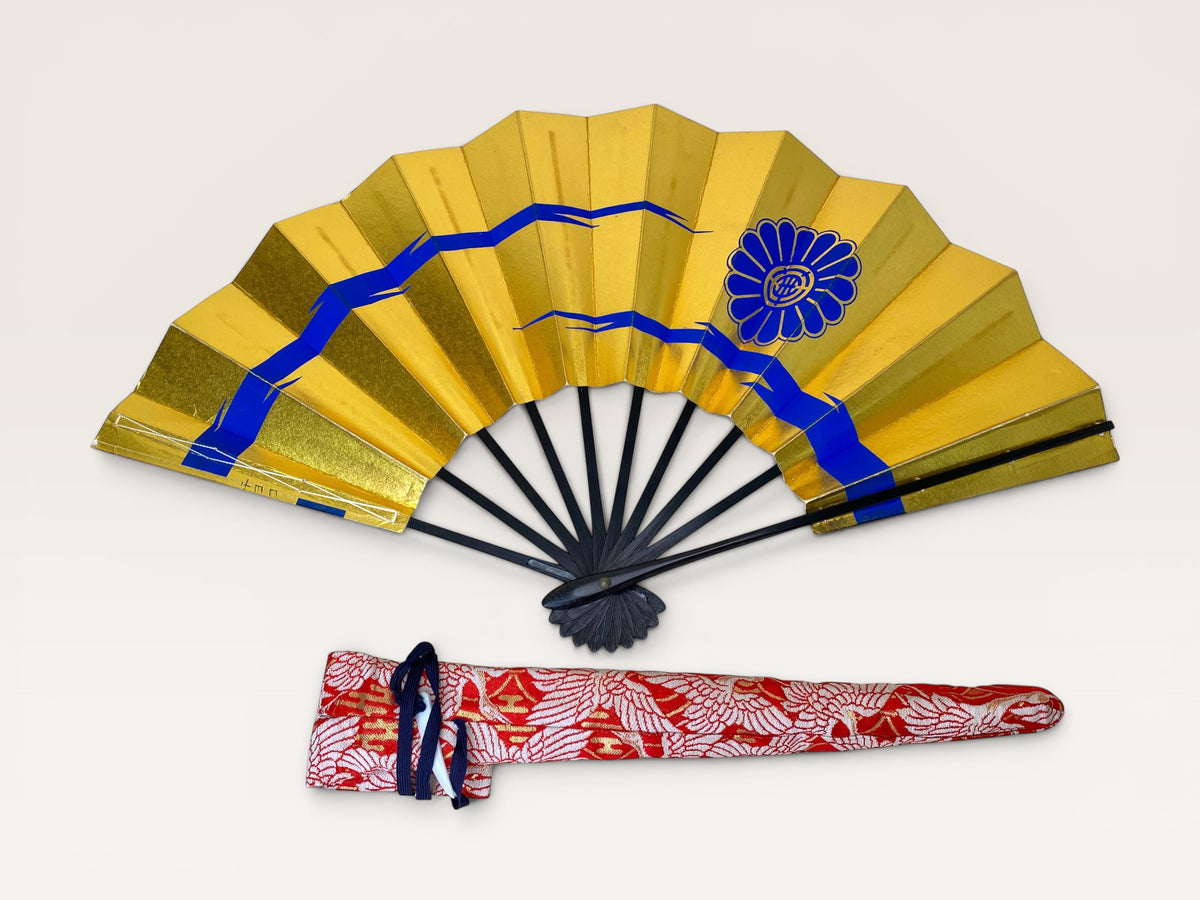 Option D: Vintage Japanese folding fan with gold surface and blue and white abstract pattern beside an orange floral carry bag.