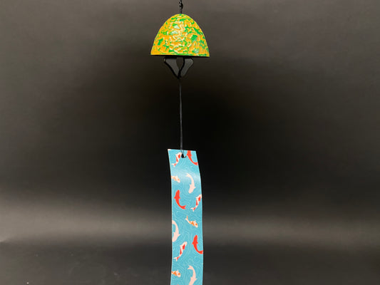 Close-up of Japanese-style cast iron wind bell showing textured green and yellow surface