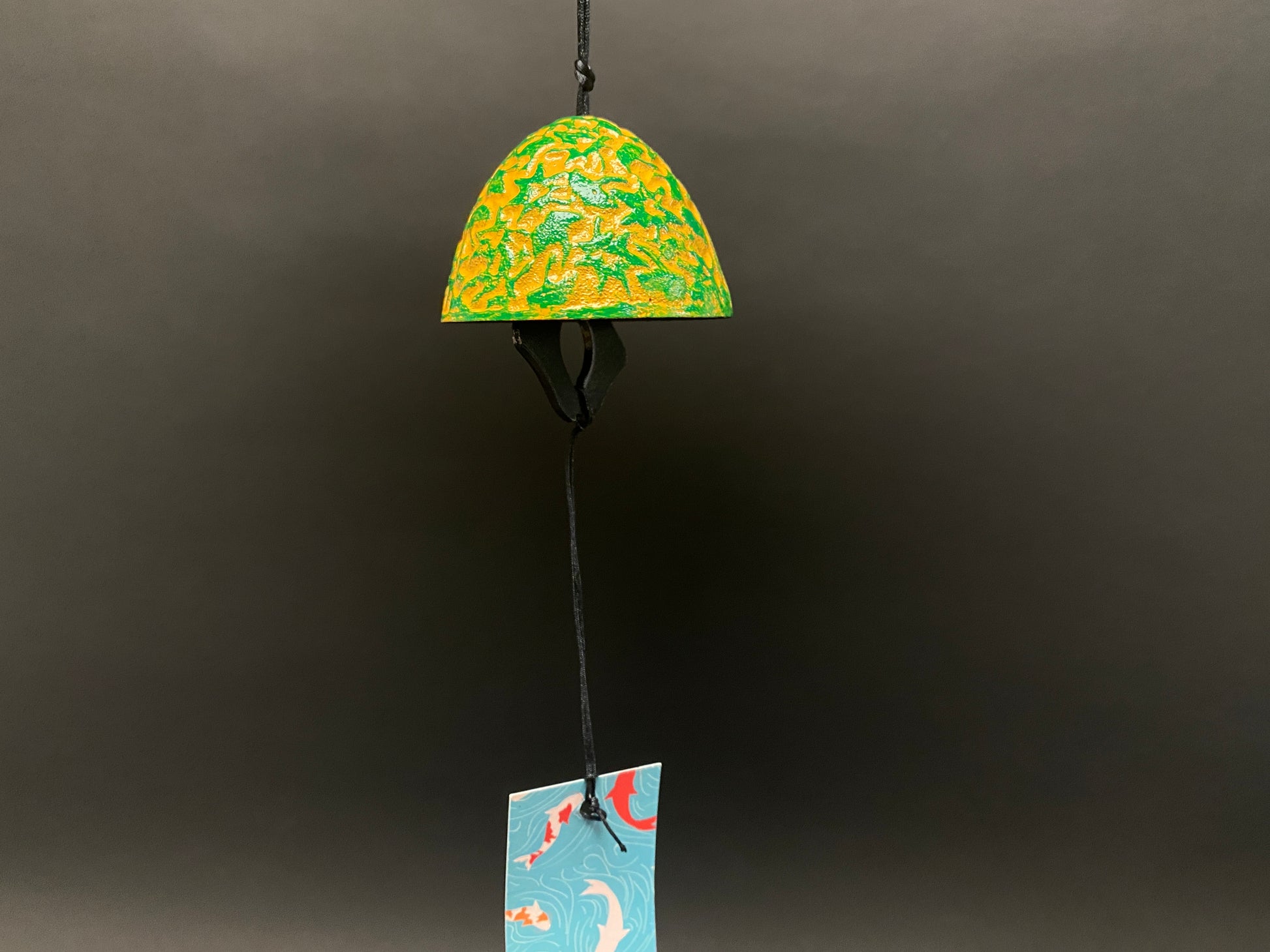 Interior view of cast iron wind bell showing dark coating and clapper mechanism