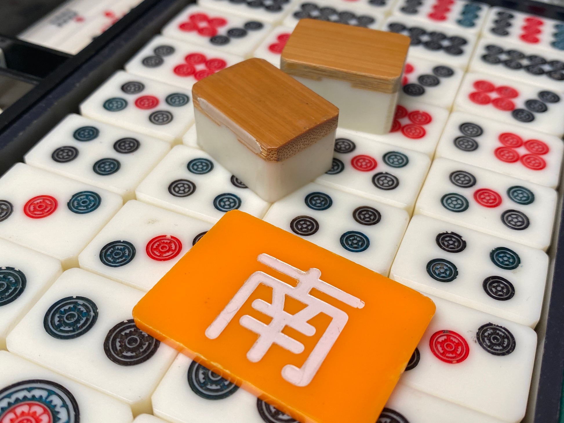 Open dark green portable mahjong case showing black interior trays