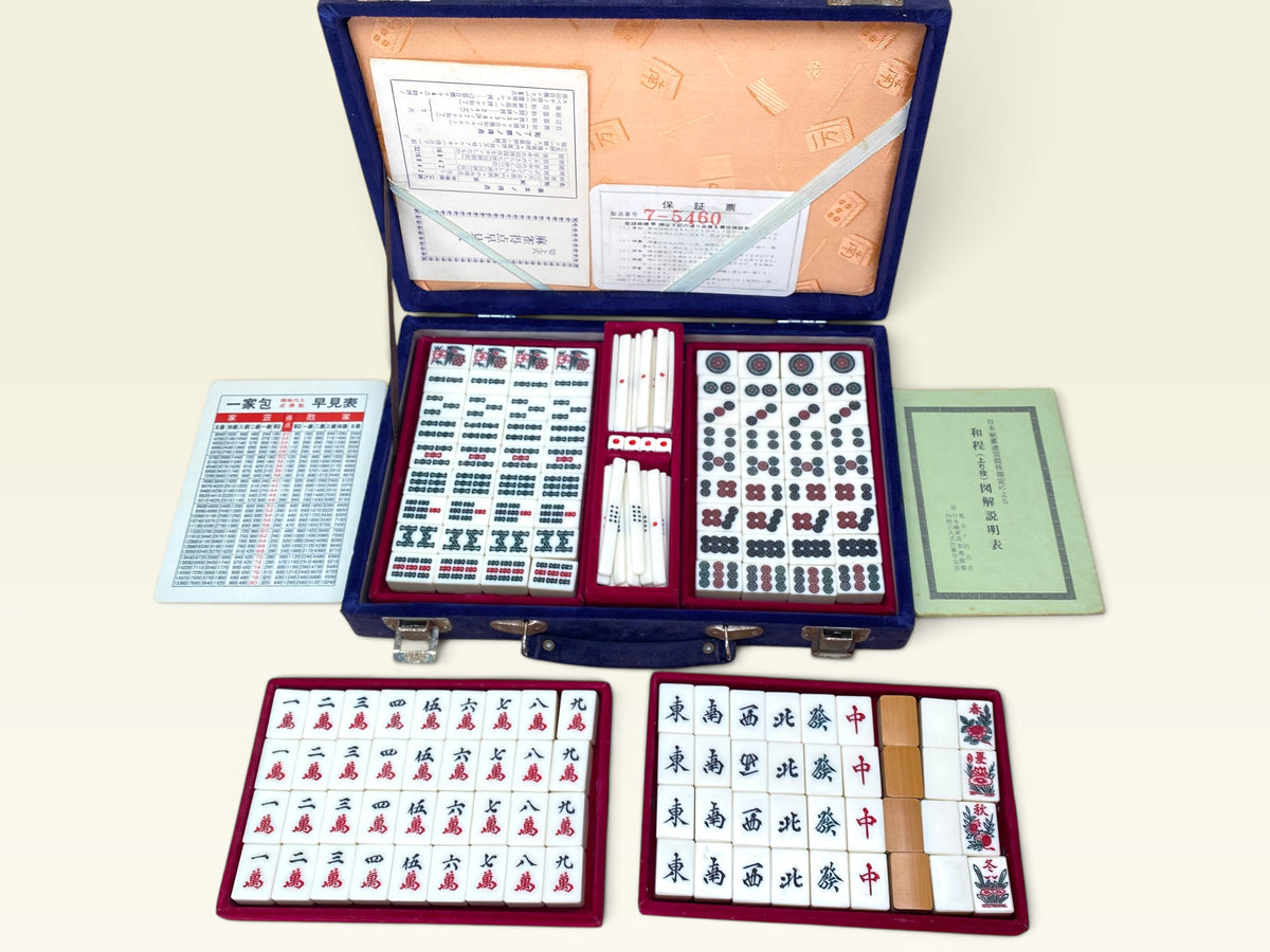 Mahjong tiles with circle suit patterns and scoring sticks in red velvet tray