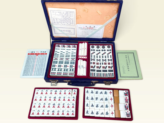 Mahjong tiles with circle suit patterns and scoring sticks in red velvet tray