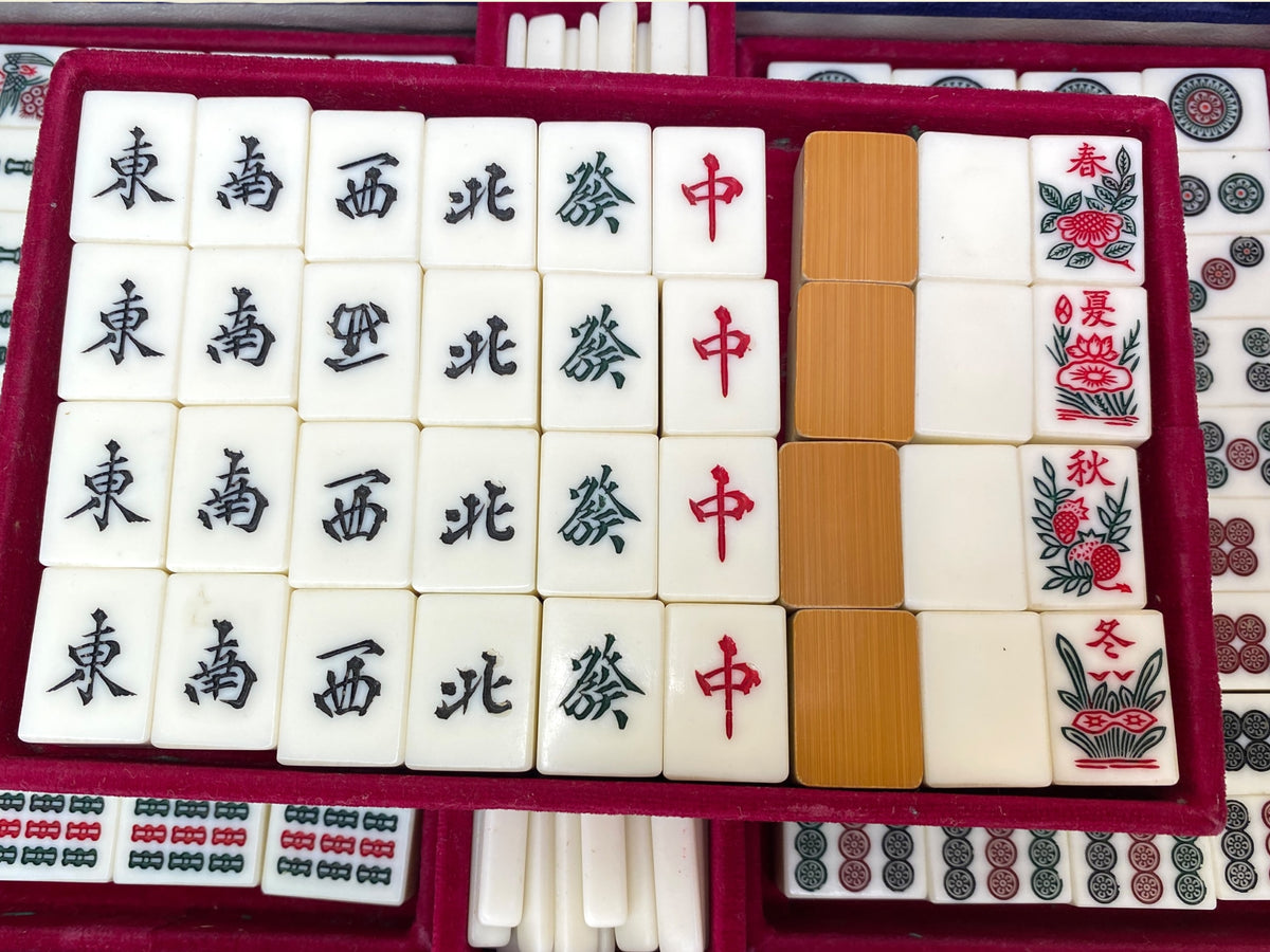 Mahjong tiles with red Chinese character Man suit markings in red velvet tray