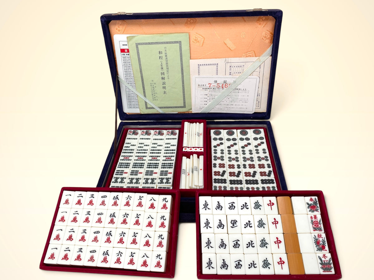 Vintage Japanese mahjong set open in blue velvet portable case with tiles, scoring sticks, dice, and instruction booklets
